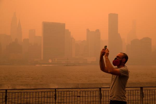 The New York City Manhattan skyline as seen from the East River in Long Island City covered in haze and smoke caused by wildfires in Canada.