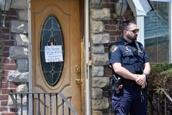 An NYPD stands guard at the house.