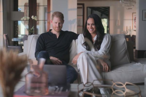 Prince Harry and Meghan Markle sitting on a couch together. 