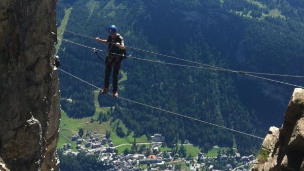 A man crosses ropes between mountains