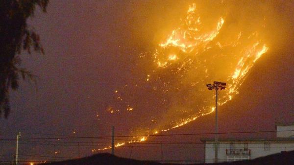 Flames rise as a wildfire burns on the hills near Palermo