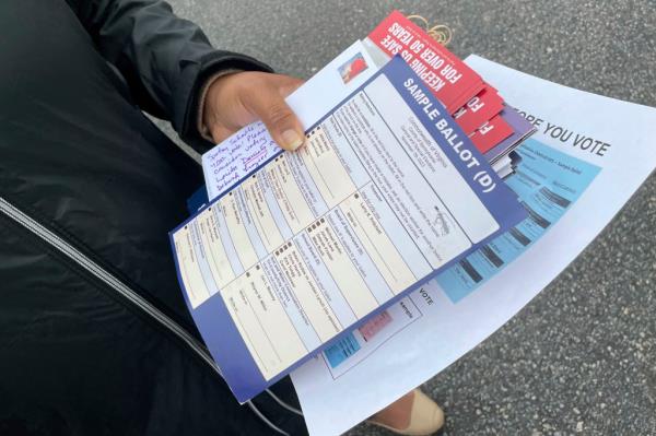 A poll volunteer displays a misleading sample ballot