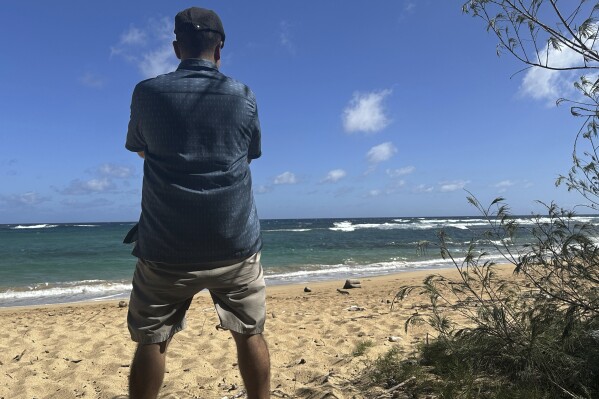 Anto<em></em>nio Perez looks out at Kawailoa Bay in Kauai, Hawaii on Nov. 5, 2023. “I was suicidal before I got into co<em></em>nspiracy theories,” said Perez, who became obsessed with Sept. 11 co<em></em>nspiracy theories and QAnon until he decided they were interfering with his life. Back then, when he first found other o<em></em>nline co<em></em>nspiracy theorists, he was ecstatic. “It’s like: My God, I’ve finally found my people!” (AP Photo/Eugene Garcia)