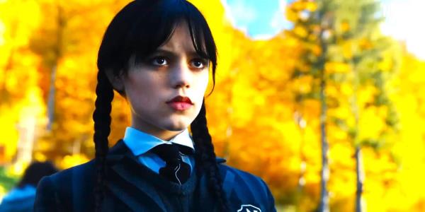 Wednesday in her Nevermore Academy uniform frowning in front of yellow trees in season 1