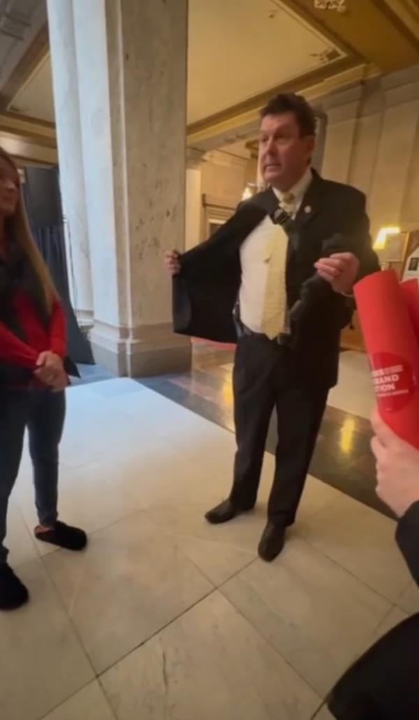 Indiana Rep. Jim Lucas flashes holstered gun.