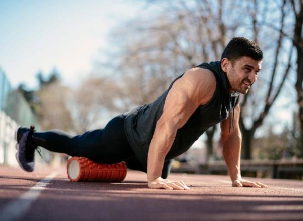 man rolling out thigh performing foam rolling exercises for knee pain