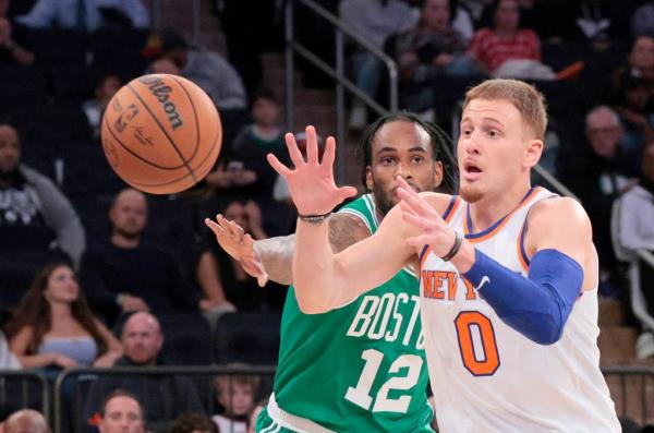 Knicks guard Do<em></em>nte DiVincenzo #0 catches a pass as Boston Celtics forward Oshae Brissett #12 defends.