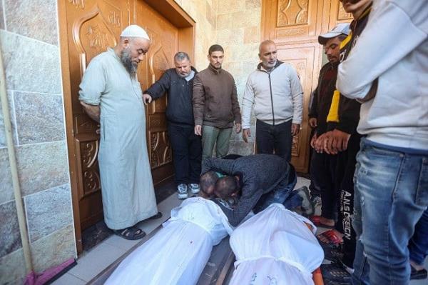 Men mourn over the body of a person killed in Israeli bombardment on Khan Yunis in the southern Gaza Strip, in front of the morgue of the Nasser hospital on December 15, 2023, as battles co<em></em>ntinue between Israel and the Palestinian resistance group Hamas. PHOTO: AFP