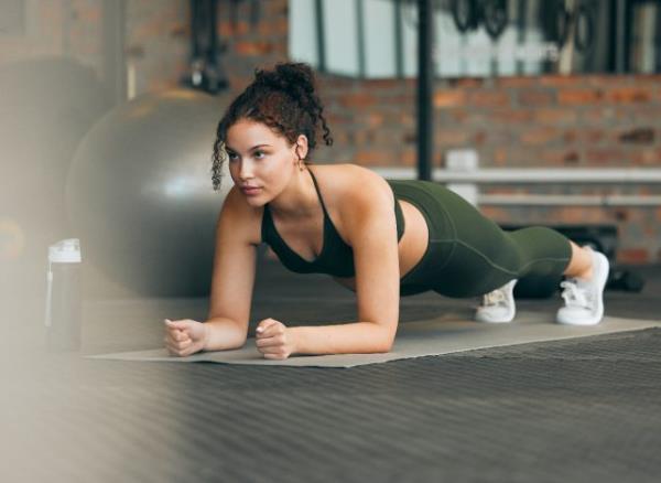 woman doing forearm plank at the gym