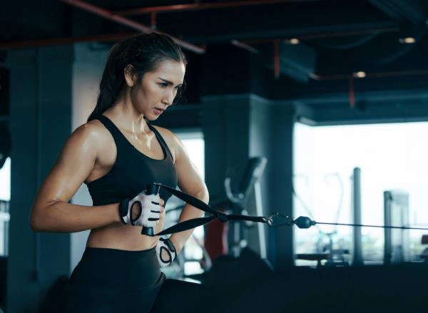 fit woman doing cable exercise at the gym co<em></em>ncept of weighted ab exercises for belly fat