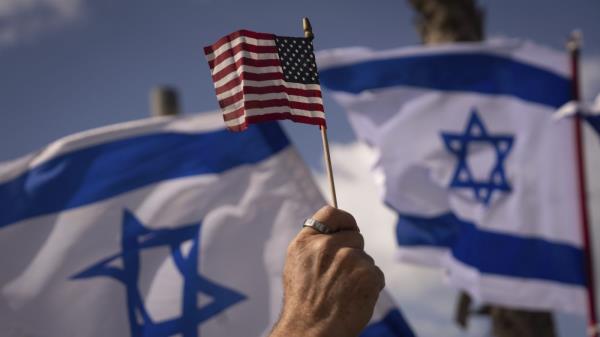 FILE - Israelis opposed to a co<em></em>ntentious government plan to overhaul the judiciary wave Israeli and American flags during a protest in support of President Joe Biden, who criticized the plan this week, outside of the U.S. Embassy Branch Office in Tel Aviv, Israel, March 30, 2023. As Biden prepares to meet Israeli Prime Minister Benjamin Netanyahu this week in New York, a new poll finds that while Americans generally view Israel as a partner or ally, many question whether his far-right government shares American values. (AP Photo/Oded Balilty, File)