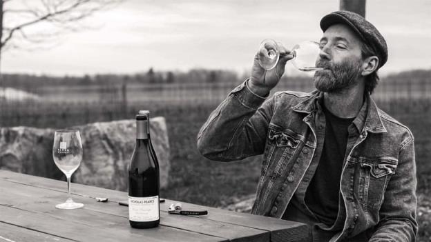 A man sitting, drinking wine.