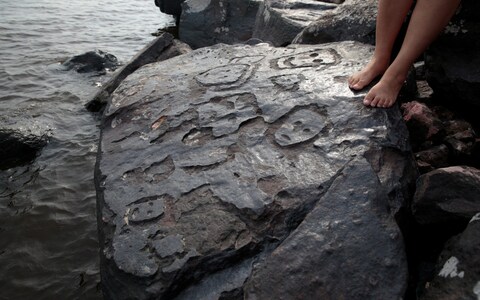 Human faces can be seen engraved into the rock at Po<em></em>nto das Lajes