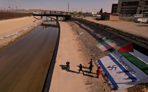 Activists paint a mural in support of Palestinians in Gaza, on the banks of the Rio Bravo river, the border between the U.S. and Mexico, in Ciudad Juarez, Mexico, November 12, 2023. The mural reads: 