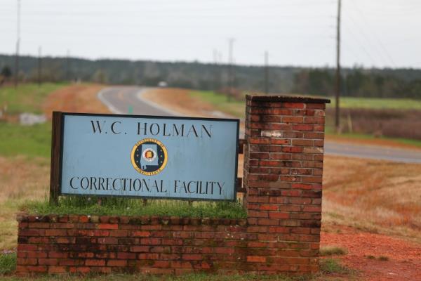 FILE -In this Saturday March 12, 2016 file photo, the sign to The William C. Holman Correctio<em></em>nal Facility in Atmore, Ala., is displayed. A priso<em></em>ner has stabbed a fellow inmate and 70 priso<em></em>ners have barricaded themselves in a dorm at an Alabama prison that was the site of weekend uprisings. The uprising was the second in three days at the prison, which was still on lockdown after inmates stabbed the prison warden and a corrections officer, lit fires and tried to take over a dormitory on Friday. (Sharon Steinmann/AL.com via AP, File)