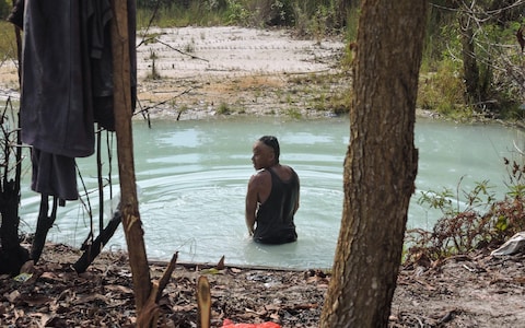 A miner taking a bath in the kulong - wher<em></em>e many are attacked - after finishing his work