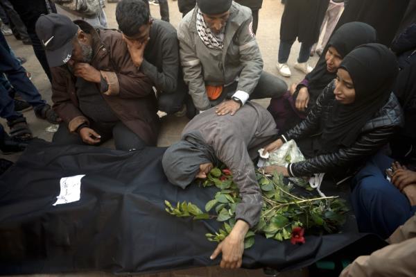 Palestinians mourn relatives killed in the Israeli bombardment of the Gaza Strip outside a morgue in Khan Younis on Sunday, Dec. 24, 2023.