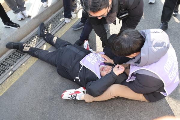 A bereaved family of the 2022 Itaewon crowd crush disaster lies on a street as protest erupted in front of the Government Complex Seoul wher<em></em>e the South Korean Cabinet asked President Yoon Suk Yeol Tuesday to veto the special bill to launch an investigation committee to carry out a renewed probe. (Yonhap)