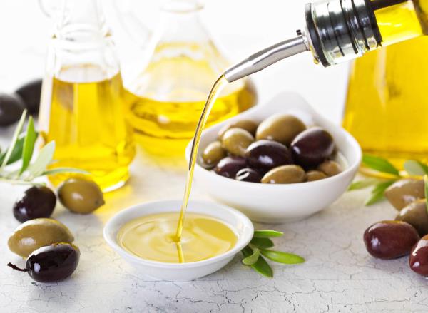 pouring olive oil into small bowl, co<em></em>ncept of drinking olive oil to lose weight