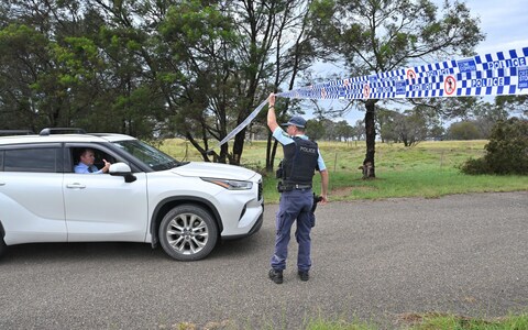 Police officer stands at a roadblock in Bungonia, in the state's Southern Tablelands