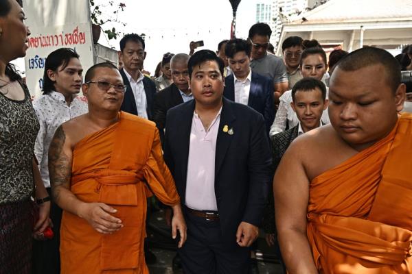 Vacharaesorn Vivacharawo<em></em>ngse walks next to mo<em></em>nks and people in Thailand.