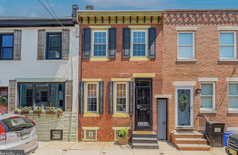 Front of Philadelphia brick rowhome with black shutters