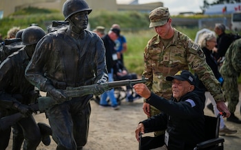 Spectators watch as UK Armed Forces parachute drop from the sky 