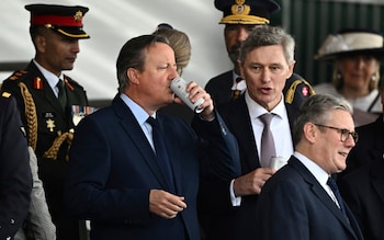 British Foreign Secretary David Cameron drinks from a can next to Labour Party leader Keir Starmer on the day of a commemorative event for the 80th anniversary of D-Day, 