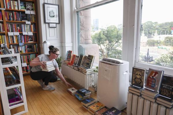 Kristen Enola Gilbert puts away books at Exile in Bookville on the second floor of the Fine Arts Building on Michigan Avenue in the Loop on Aug. 2, 2023. 