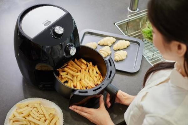 Air fryer being used to cook chips.