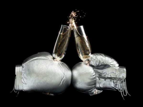 3D illustration of two shiny me<em></em>tallic boxing gloves with glass of champagne.