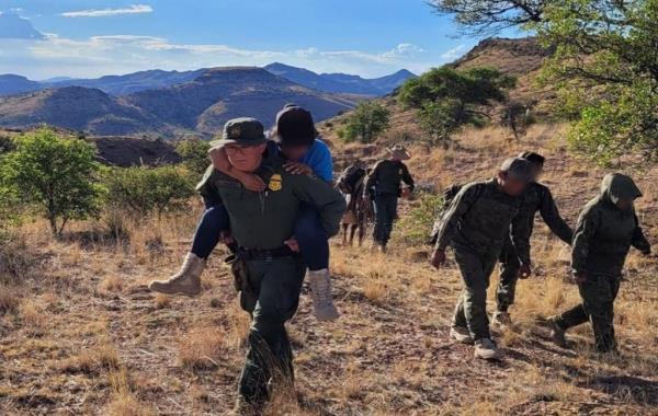 A stranded migrant in Charity Canyon near Cloverdale, New Mexico is carried on the back of a Border Patrol agent, the agency said Aug. 4.