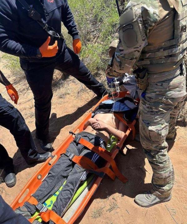 Agents in the El Paso sector of the Border Patrol carry a man to a waiting ambulance for medical care.