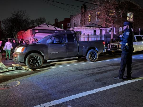 A police officer standing in front of a truck at 100 street and 31 avenue in Queens, wher<em></em>e a vehicle hit 2 children, killing 1.