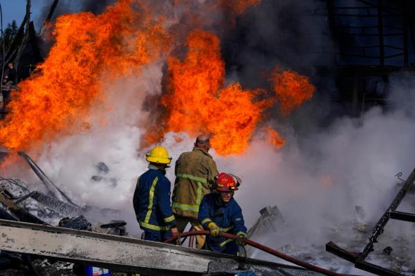 Lebanese firefighters put out flames from an Israeli airstrike in Ghazieh. 