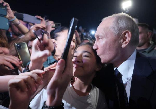 The 70-year-old Russian president kissed the top of a girl's head in the crowd during the meet-and-greet. 