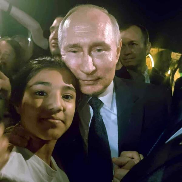 Putin poses for a picture with a young resident of Derbent 