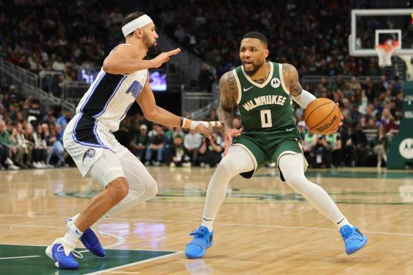 Damian Lillard #0 of the Milwaukee Bucks is defended by Jalen Suggs #4 of the Orlando Magic during the first half of a game at Fiserv Forum on April 10, 2024 in Milwaukee, Wisconsin.