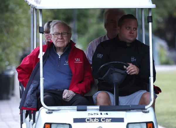 Warren Buffet arrives by golf cart.