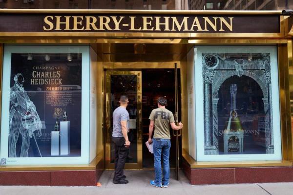 A man in an FBI t-shirt and another man outside the door of Sherry-Lehmann