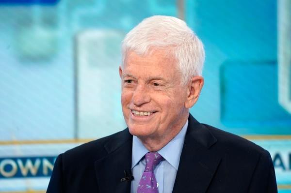 Smiling Mario Gabelli sitting down for an interview.