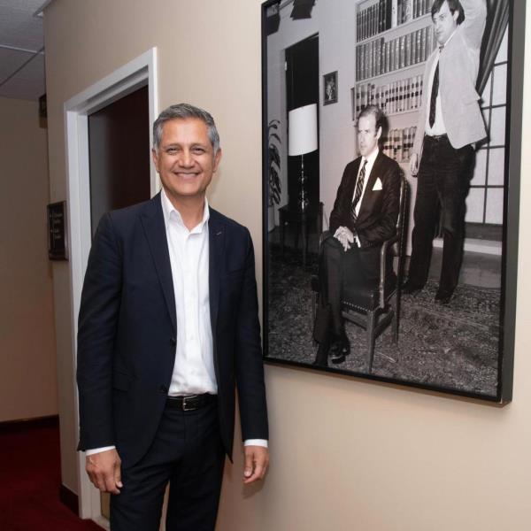 Joe Kianis in front of a black and white portrait of Joe Biden when he was a senator.