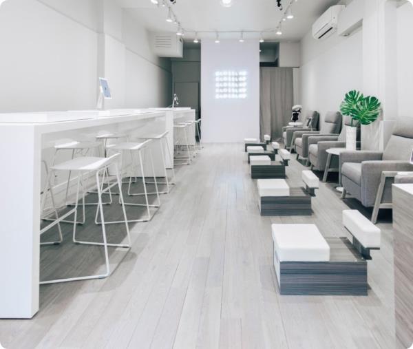 A white room with chairs in GlossLab West Village, a nail salon wher<em></em>e customers pay mo<em></em>nthly membership fees for unlimited manicures and pedicures.