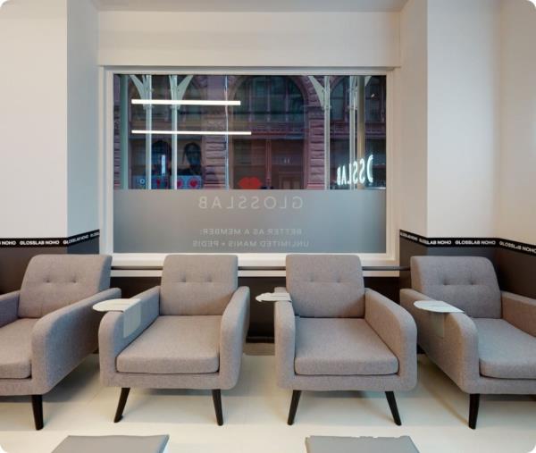 A beauty salon with chairs and tables for nail treatments.