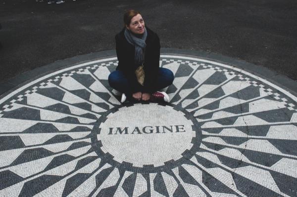 Theresa Humphrey sitting at the Imagine memorial in Central Park