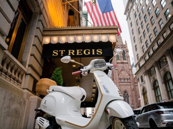 A white Vespa scooter parked in front of the St Regis hotel in New York