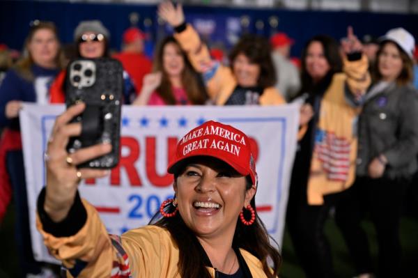 A woman taking a selfie in front of a crowd of people at a campaign event with former US President Do<em></em>nald Trump in Las Vegas.