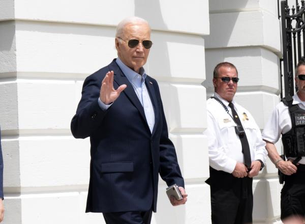 Joe Biden waves while do<em></em>nning sunglasses outside the White House 