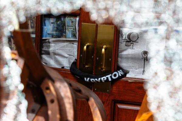 A door inside Hamilton Hall at Columbia is shown locked with a bike lock, with newspapers covering the shattered glass door.