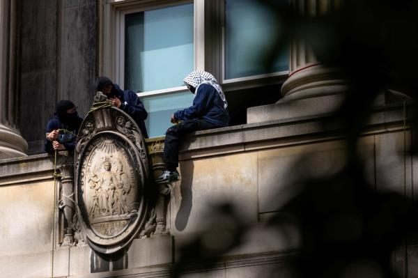 Masked protestors on ledge of Hamilton Hall, Columbia University.